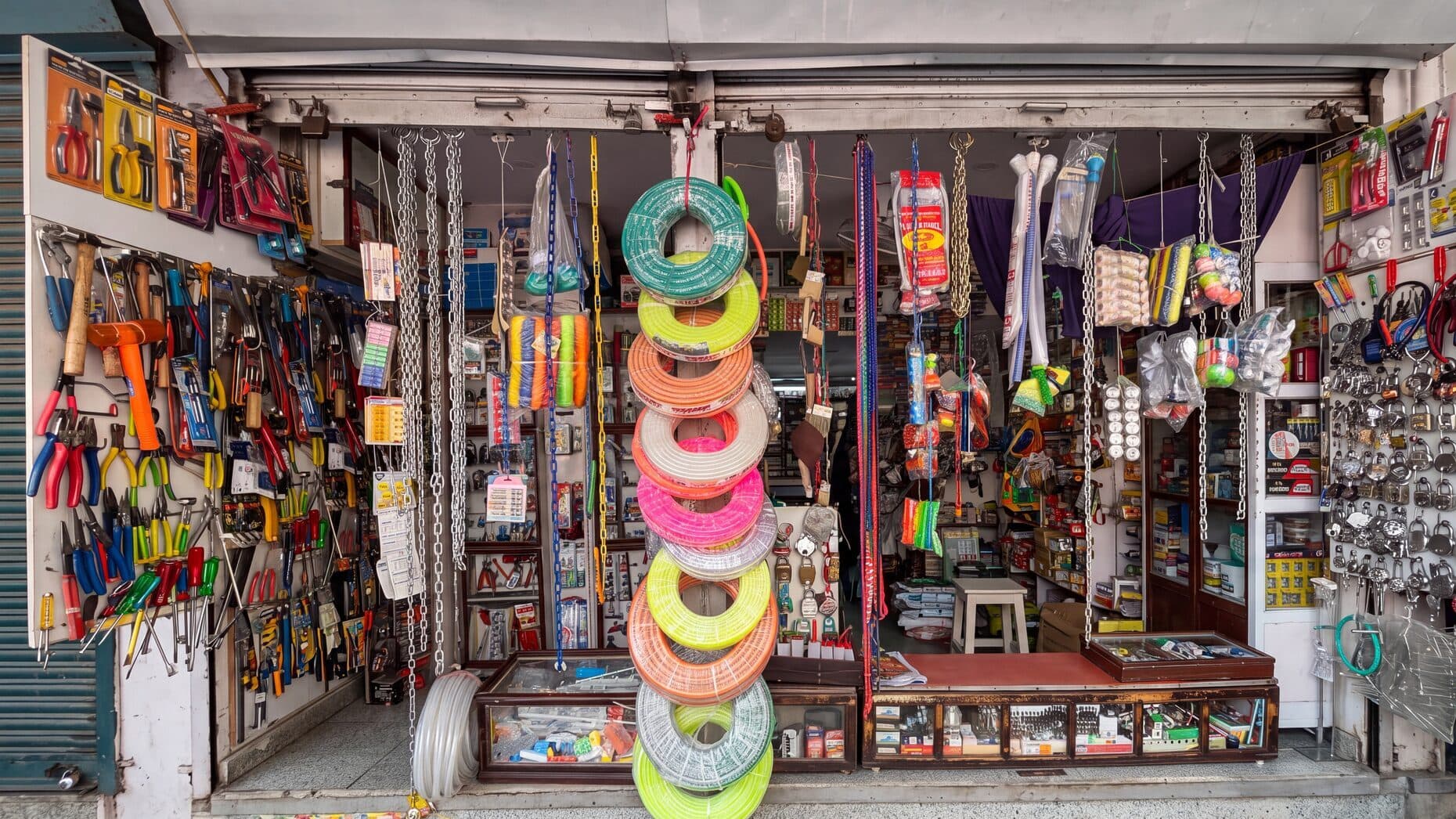 The Narender & Sons shop front in Teliwara, Sadar Bazar, with coiled pipe, chains, tools and padlocks on display